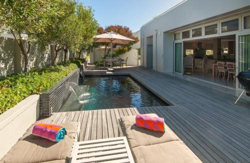 a backyard with a swimming pool and a house at Spatalla Holiday Homes in Kleinmond