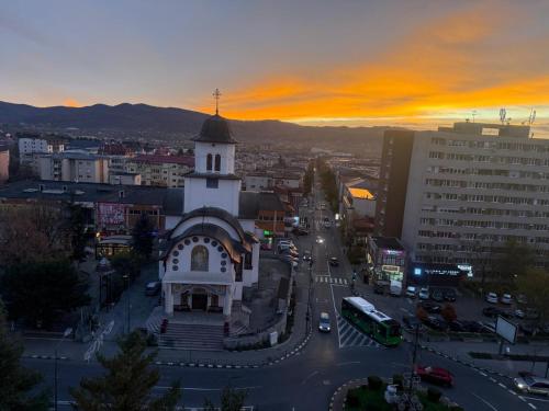 a church with a clock tower in a city at Ioana Home in Râmnicu Vâlcea