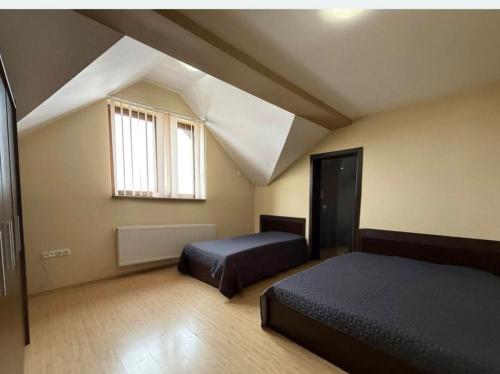 a attic bedroom with two beds and a window at Alfa Mall in Sibiu