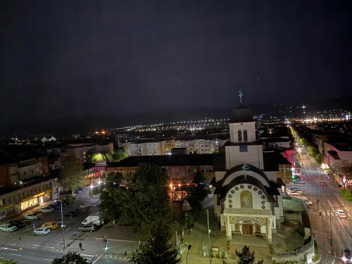 a building with a clock tower in a city at night at Ioana Home in Râmnicu Vâlcea