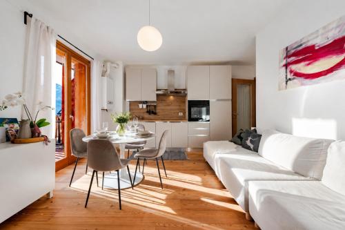 a living room with a white couch and a table at Siera Essence Apartments - Comfort e Relax a Sappada in Sappada