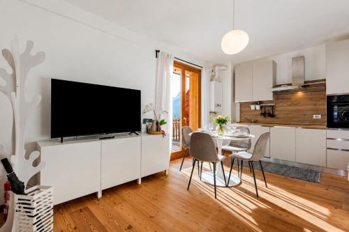 a kitchen and dining room with a flat screen tv at Siera Essence Apartments - Comfort e Relax a Sappada in Sappada