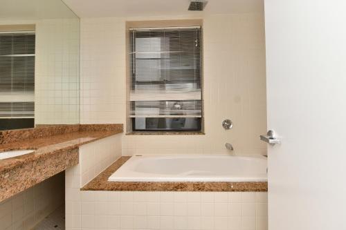 a white bathroom with a tub and a window at Elegant FiDi 3BR Condo - Private Elevator - Modern Luxury in New York