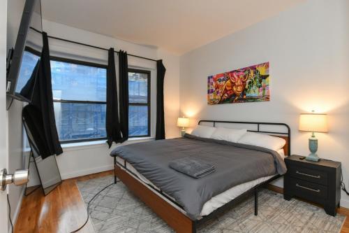 a bedroom with a bed and a large window at Elegant FiDi 3BR Condo - Private Elevator - Modern Luxury in New York