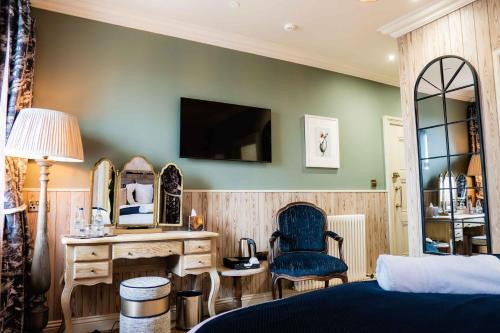 a bedroom with a bed and a desk and a mirror at The Nest at The Woodmans in Whickham