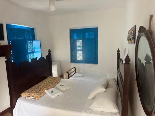 a bedroom with two beds with blue shuttered windows at Pousada santa rita in Paraty