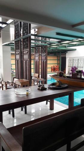 a dining room with a table and a swimming pool at Baan Tanwa - MRT Ratchadapisek in Bangkok