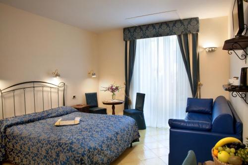 a bedroom with a bed and a couch and a chair at Hotel L'Antico Convitto in Amalfi