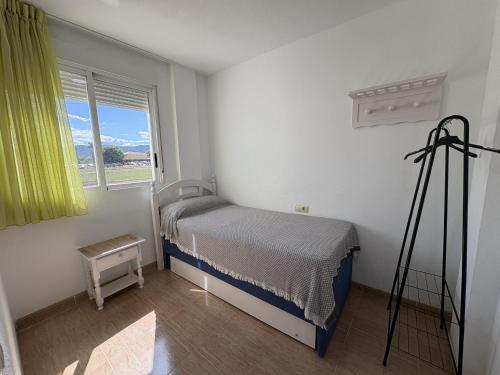 a small bedroom with a bed and a window at Alpen 1 Voramar Playa Norte in Peniscola