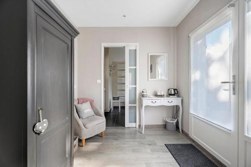 a room with a chair and a desk and a window at Rêves d'Emeraude in Cancale