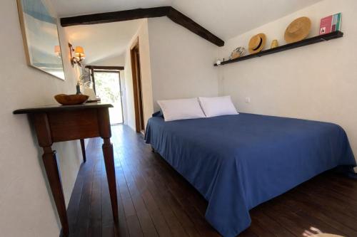 a bedroom with a blue bed and a table at La chambre du Mazet in Fayence