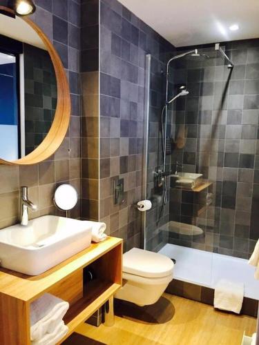 a bathroom with a sink and a toilet and a shower at Hotel les voyageurs in Saint-Renan