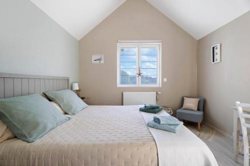 a bedroom with a large bed and a window at Rêves d'Emeraude in Cancale