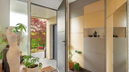 a pivot door in a room with plants in it at Chambre calme avec petit déjeuner in Gévezé