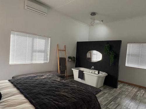 a bedroom with a bed and a tub and a sink at ikibiki in Beaufort West