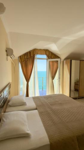 a bedroom with a large bed with a window at Hotel Lazuri in Kvariati