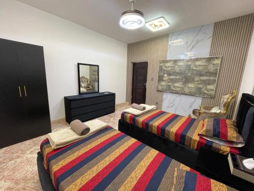 a room with two beds and a dresser in it at Garden Villa 4, Ajman in Ajman 