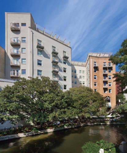 a river in front of two tall buildings at Riverside Suites Resort 1BR Apartment in San Antonio