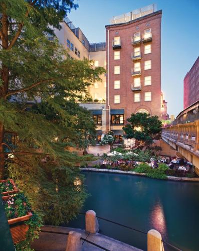 a view of a river in front of a building at Riverside Suites Resort 1BR Apartment in San Antonio