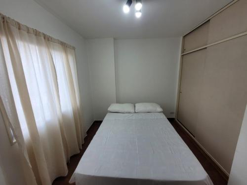 a bed in a room with a window at Alto Valle Home in Cipolletti