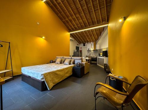 a bedroom with a bed and a yellow wall at Sons da Ribeira in Ribeira Grande