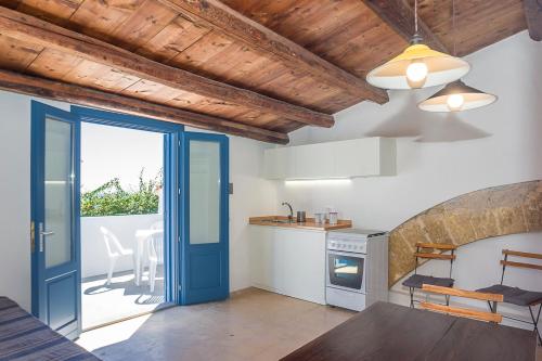 a kitchen with a blue door leading to a patio at Vero Sicily - Balloniera In Solanto in Santa Flavia