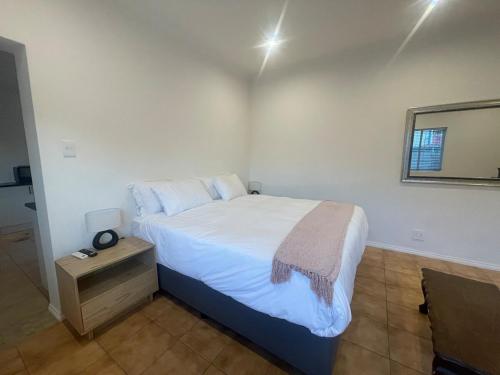a bedroom with a large bed and a mirror at Comfort & Convenience in Edenvale