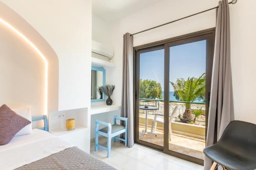 a bedroom with a bed and a view of the ocean at Sun Beach Apartments in Karpathos