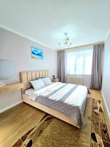 a bedroom with a large bed and a window at Двухкомнатная "Аэропорт Астана" in Prigorodnyy