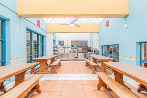 an empty cafeteria with wooden benches and tables at HI Faro – Pousada de Juventude in Faro