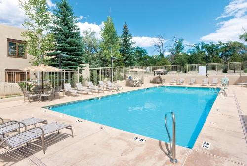 a swimming pool with chaise lounge chairs at Taos Resort Studio Apartment in Taos
