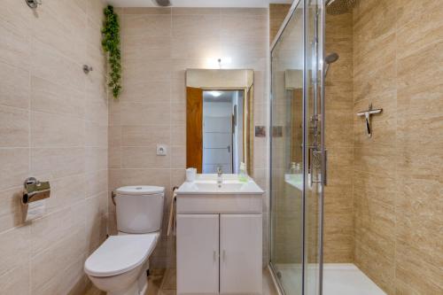 a bathroom with a toilet and a sink and a shower at Gîtes Villa Beau Soleil Agde in Agde