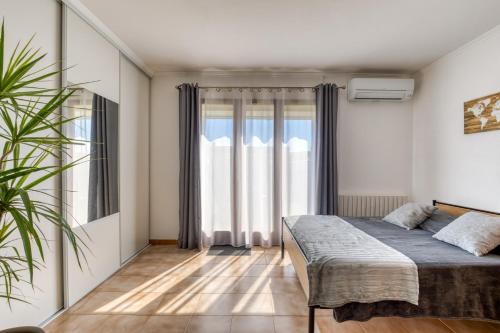 a bedroom with a bed and a large window at Gîtes Villa Beau Soleil Agde in Agde