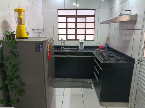 a kitchen with a refrigerator and a sink at Casa no centro de Brumadinho in Brumadinho