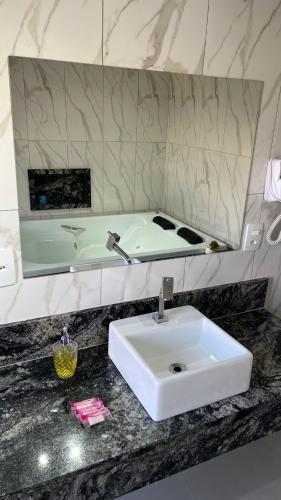 a bathroom with a white sink and a mirror at Pousada do Irlandês in Pirenópolis