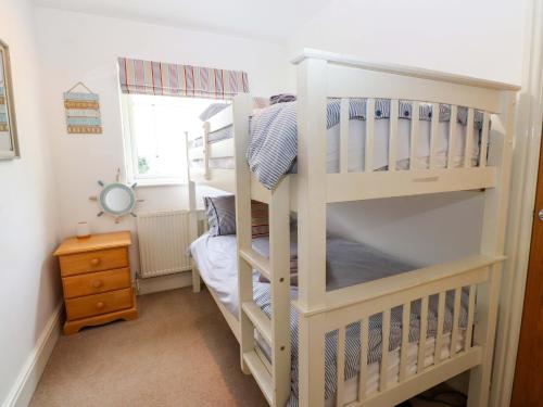 a white bunk bed in a small room at The Bungalow in Pwllheli