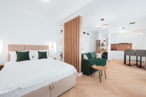 a bedroom with a large bed and a green chair at Victory SeaSide Studio in Mangalia