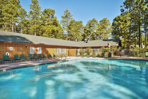 a large swimming pool with chairs and a building at Pinetop Resort Studio Apartment in Pinetop-Lakeside