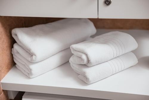 a pile of towels on a shelf in a bathroom at Victory SeaSide Studio in Mangalia