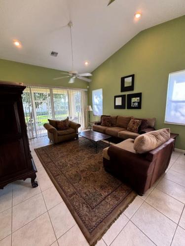 a living room with two couches and a rug at Right Direction Rentals Carnoustie Townhome in Port Saint Lucie