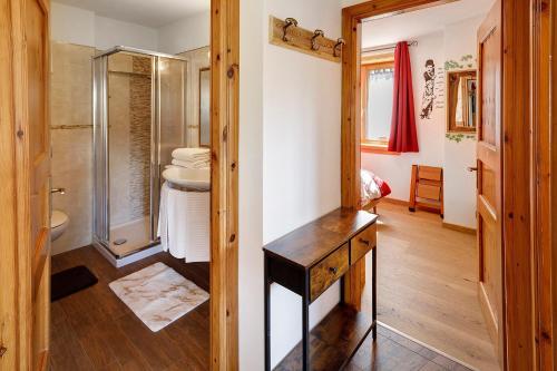 a bathroom with a shower and a wooden table at Appartamenti Fabrizio in Livigno