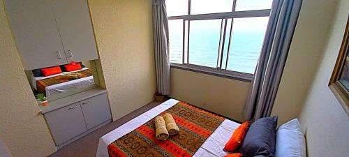 a small room with a window and a bed with a pillow at Apartment on doonside Beach in Kingsborough