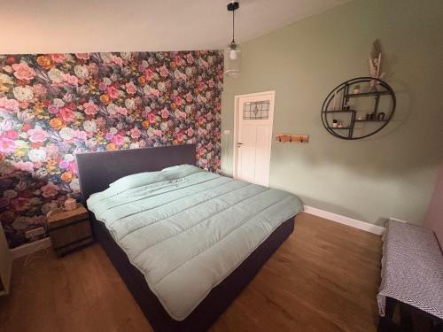 a bedroom with a flower mural on the wall at B&B Chili Hoeve in Wanroij
