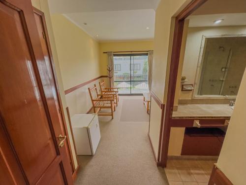 a hallway with a bathroom with a sink and a mirror at Hotel Los Sauces in Cafayate