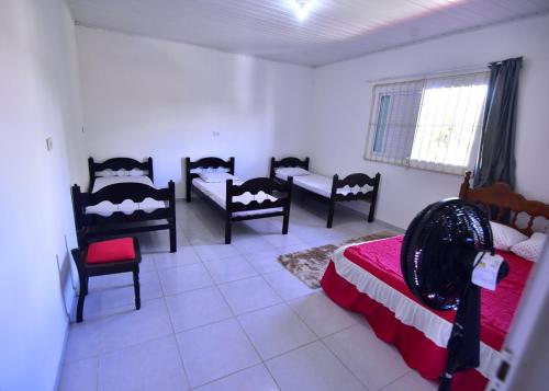 a bedroom with four beds and chairs in a room at Casa Rosi in Pitimbu