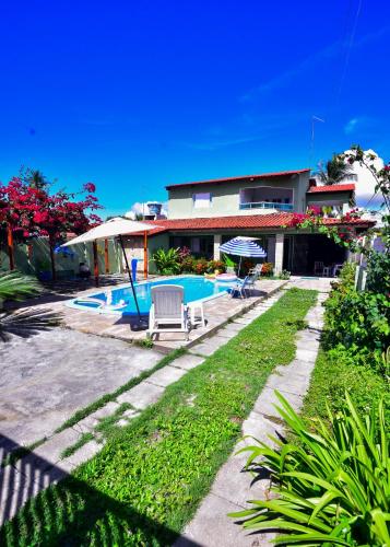 a house with a swimming pool in front of it at Casa Rosi in Pitimbu