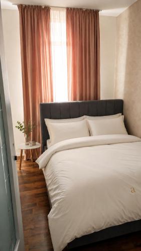 a bedroom with a large white bed and a window at Adori Apartment in Eforie Nord