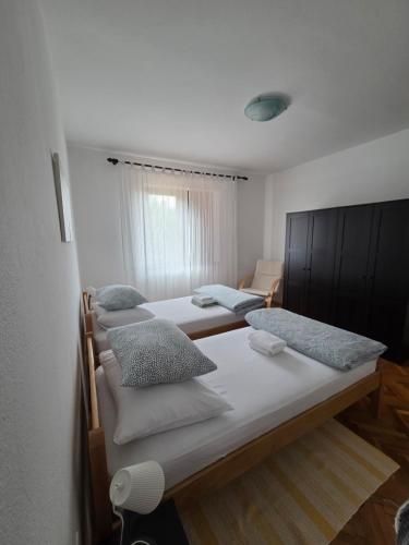 a group of beds in a room at Apartments Valiza III Large apartment - 3 bedrooms and parking space i Apartments Valiza IV in Senj