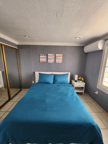 a bed in a room with a blue bed at Vista Azul Apartment in Punta Santiago