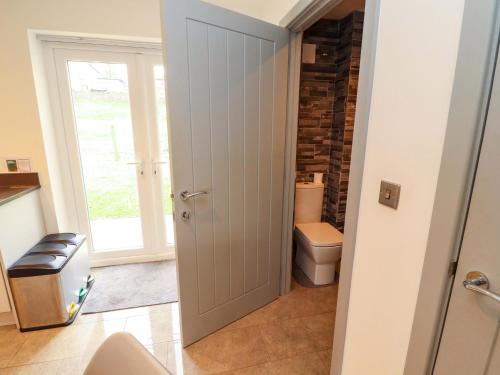 a bathroom with a toilet and a door at 11 The Forge in Brampton